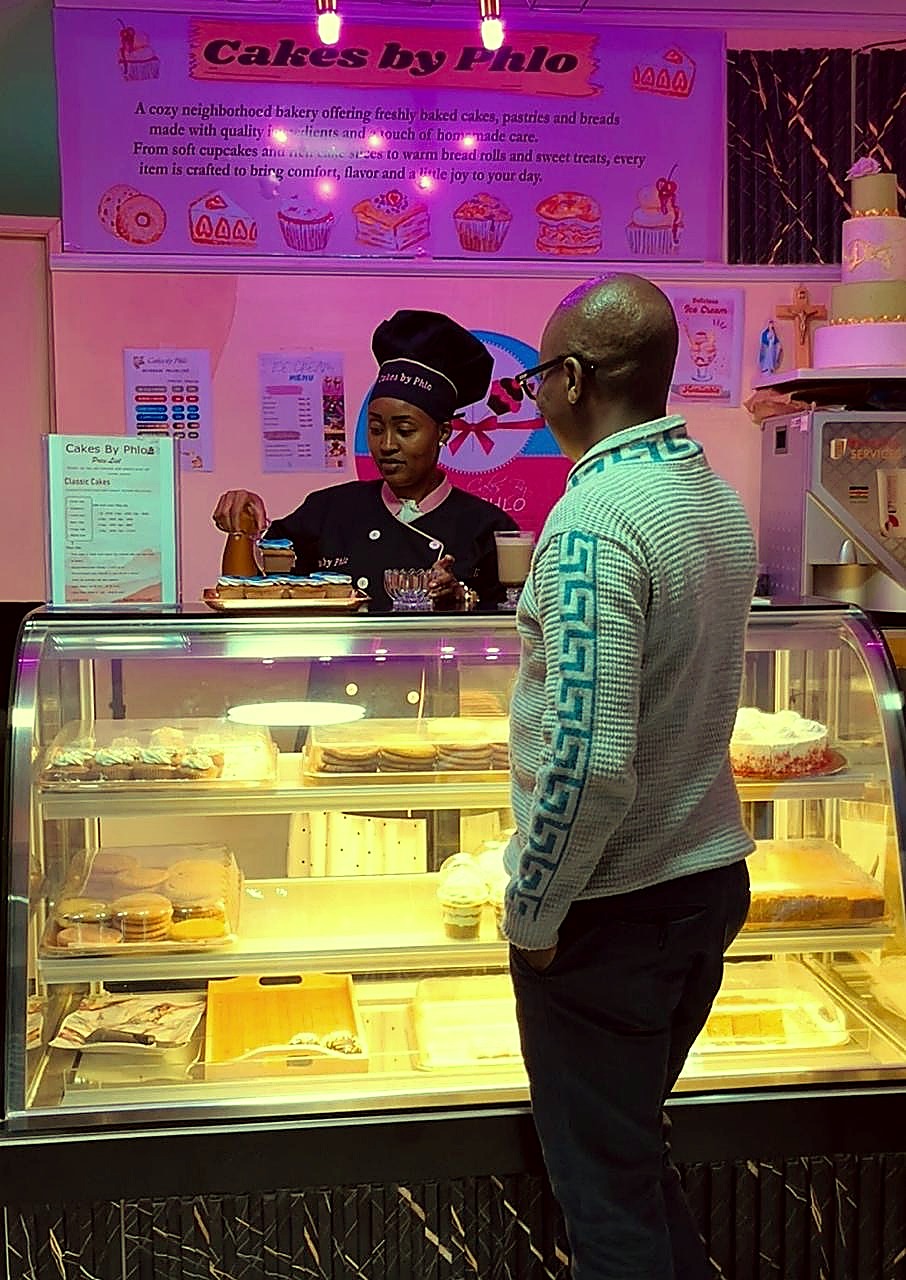 Customer being served at the Cakes by Phlo bakery counter in Buruburu